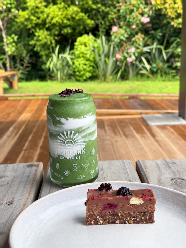 A green smoothie and sweet treat on an outdoor table