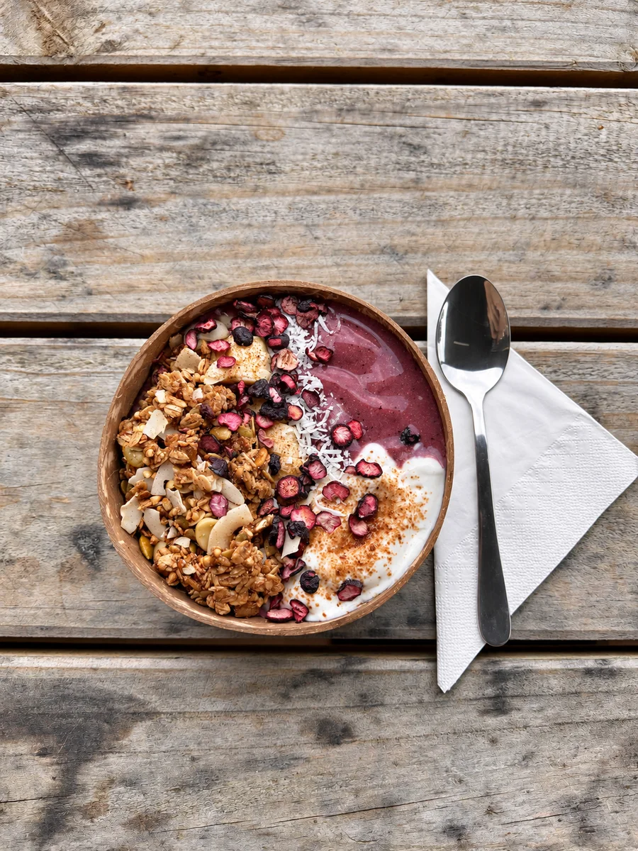 A purple smoothie bowl with granola and fruit